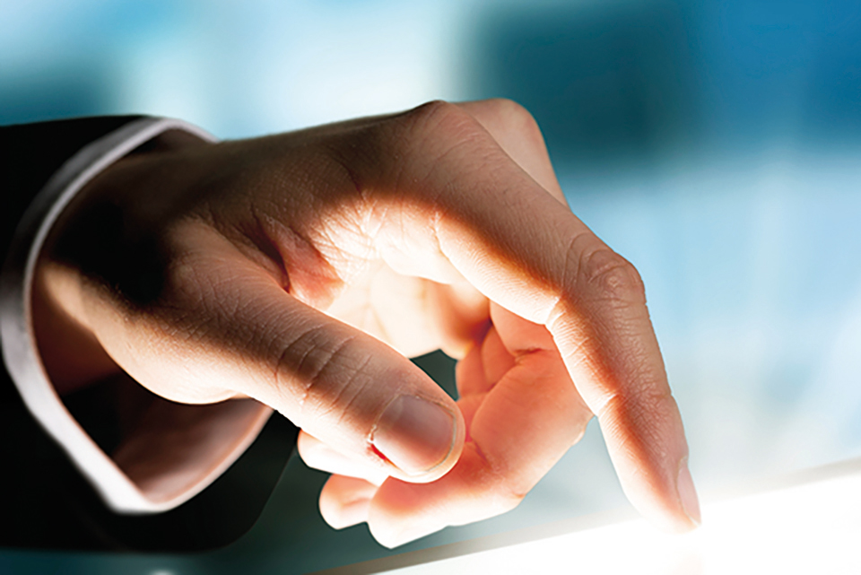 Image of a hand touching an interactive screen