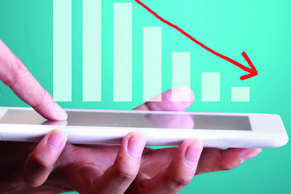 Photo of a graph showing decreasing values over the top of a tablet