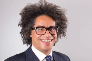 head and shoulders of bespectacled man in suit and tie