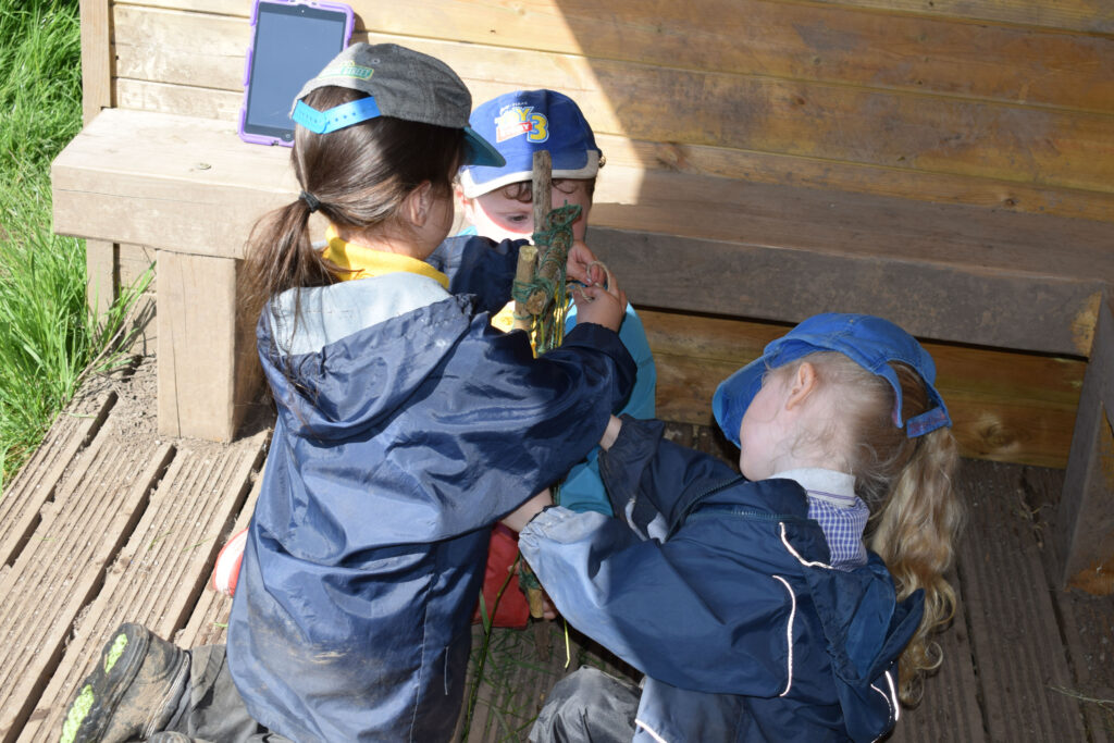 Three young children in a playground shelter