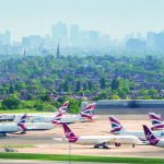 View of planes at Heathrow airport, with London skyline in the background