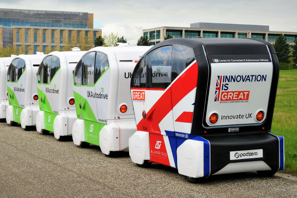 Image of prototype driverless vehicles in UK Autodrive and 'GREAT' campaign livery
