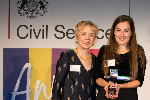 Charlotte Dring, Civil Service Award winner for Diversity and Inclusion, on stage with award presenter Sue Owen, Permanent Secretary, Department for Digital, Culture, Media & Sport, at the award presentation in front of a display with the Civil Service awards logo