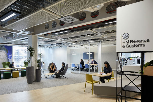 Interior view of HM Revenue and Customs offices in the Government Hub in Canary Wharf, London, showing people working at desks and in meetings