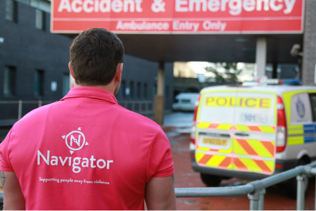 A member of the Scottish Government Navigator programme, wearing a T-shirt with programme branding, photographed outside an Accident and Emergency unit