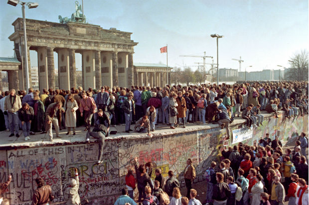 Berliners stand on a section of the Berlin Wall, two days after the fall of the GDR on 11 November 1989